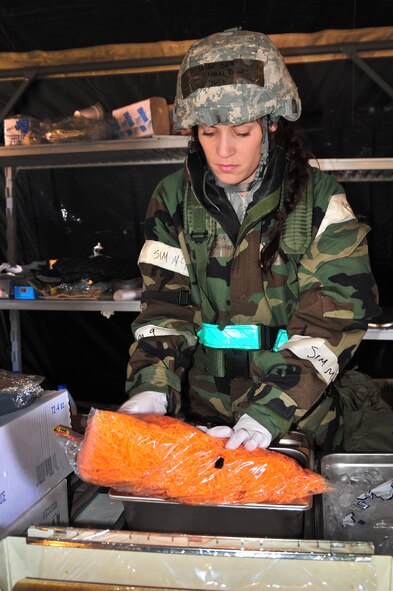 U.S. Air Force Senior Airman Diana Fishman, a member of the 140th Force Support Squadron, prepares food to be served at the simulated deployed Single Pallet Expeditionary Kitchen during an Operational Readiness Exercise at Buckley Air Force Base Colo., March 10, 2012. Guard members are taking part in the exercise to prepare for real world deployments as well as the upcoming Operational Readiness Inspection in May.    (U.S. Air Force photo by Tech. Sgt. Wolfram M. Stumpf)