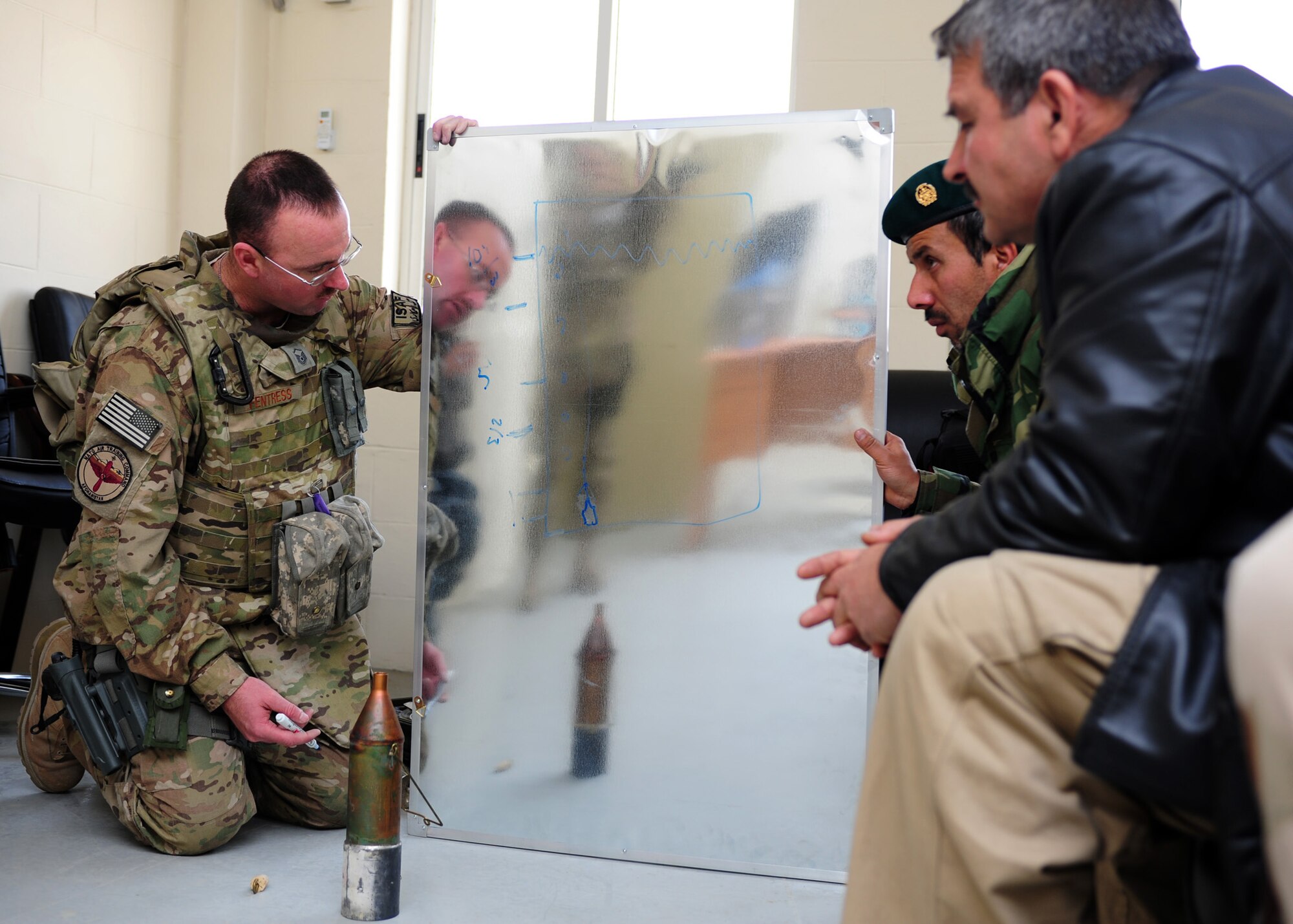 Master Sgt. Jeremiah Fentress, a fuels advisor with the 439th Air Expeditionary Advisory Squadron, draws a diagram explaining the proper use of the use of weight bottles and bacon-bomb samplers to a group of Afghan air force fuels specialists during a basic fuels laboratory analysis training class at Kabul International Airport, March 5, 2012. In addition to analyzing fuels samples, students received specialized training needed to properly perform an American Petroleum Institute (API) density test, Fuels System Icing Inhibitor (FSII) test, Conductivity Unit (CU) test and an inline sample test. (U.S. Air Force photo by Staff Sgt. Nadine Y. Barclay)