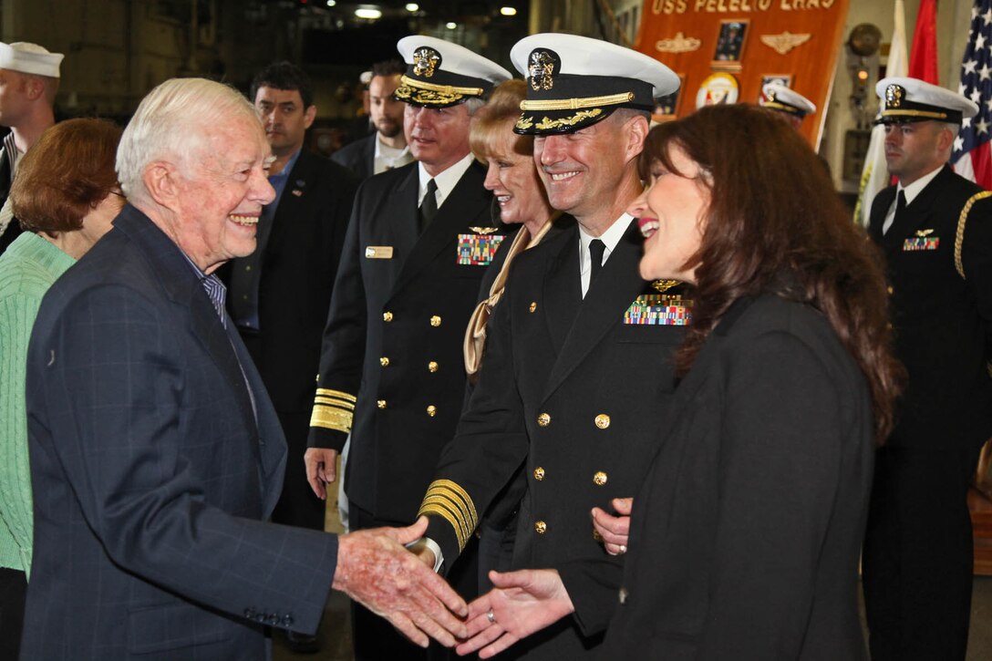 Former President Jimmy Carter greets Navy Capt. James T. Cox, commanding officer, USS Peleliu, during a visit to the ship by members of the Carter Center, Mar. 10. Members of the Carter Center flew from all parts of the U.S. to see the Peleliu Amphibious Ready Group and learn about the capabilities of the 15th Marine Expeditionary Unit.