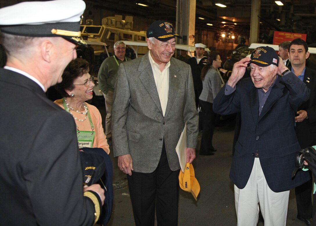 Former President Jimmy Carter tries on a new hat given to him by the crew of the USS Peleliu during a visit of the ship Mar. 10. Carter Center members flew from all parts of the U.S. for the Carter Center Winter Weekend and were able to take a tour of the ship and learn about the capabilities of the 15th Marine Expeditionary Unit.