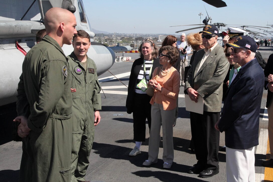 Distinguished visitors including Former President Jimmy Carter and former Secretary of the Navy John H. Dalton, speak with Marines from Marine Medium Helicopter Squadron 364, during a visit to the USS Peleliu, Mar. 10. The visitors flew from all parts of the U.S. for the Carter Center Winter Weekend and were able to see firsthand the USS Peleliu and learn about the capabilities of the 15th Marine Expeditionary Unit.