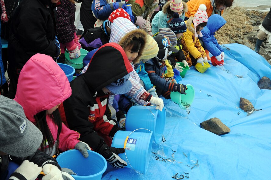 Children from local Japanese communities release baby salmon into the Oirase River at Oirase Salmon Park in Oirase Town, Japan, March 10, 2012. More than 200 participants from Misawa Air Base and the local communities participated in this year's event, which was part of Earth Day 2012. (U.S. Air Force photo by Tech. Sgt. Marie Brown/Released)