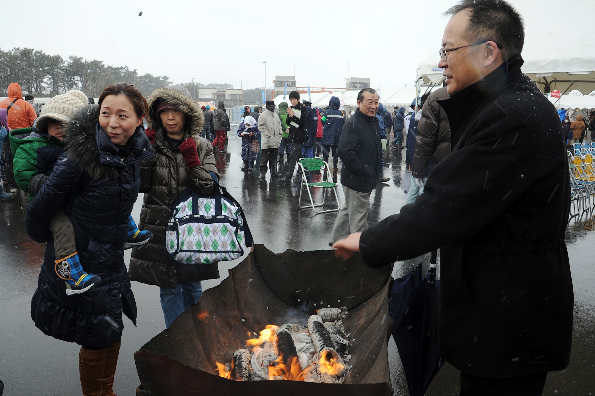 Local Japanese families stay warm over a fire at the remembrance ceremony in Oirase Town, Japan, March 11, 2012. A crowd of more than 500 people, including families from Misawa Air Base, paid tribute to those who lost their lives during the 9.0 magnitude earthquake and subsequent tsunami that occurred on March, 11, 2011. (U.S. Air Force photo by Tech. Sgt. Marie Brown/Released)