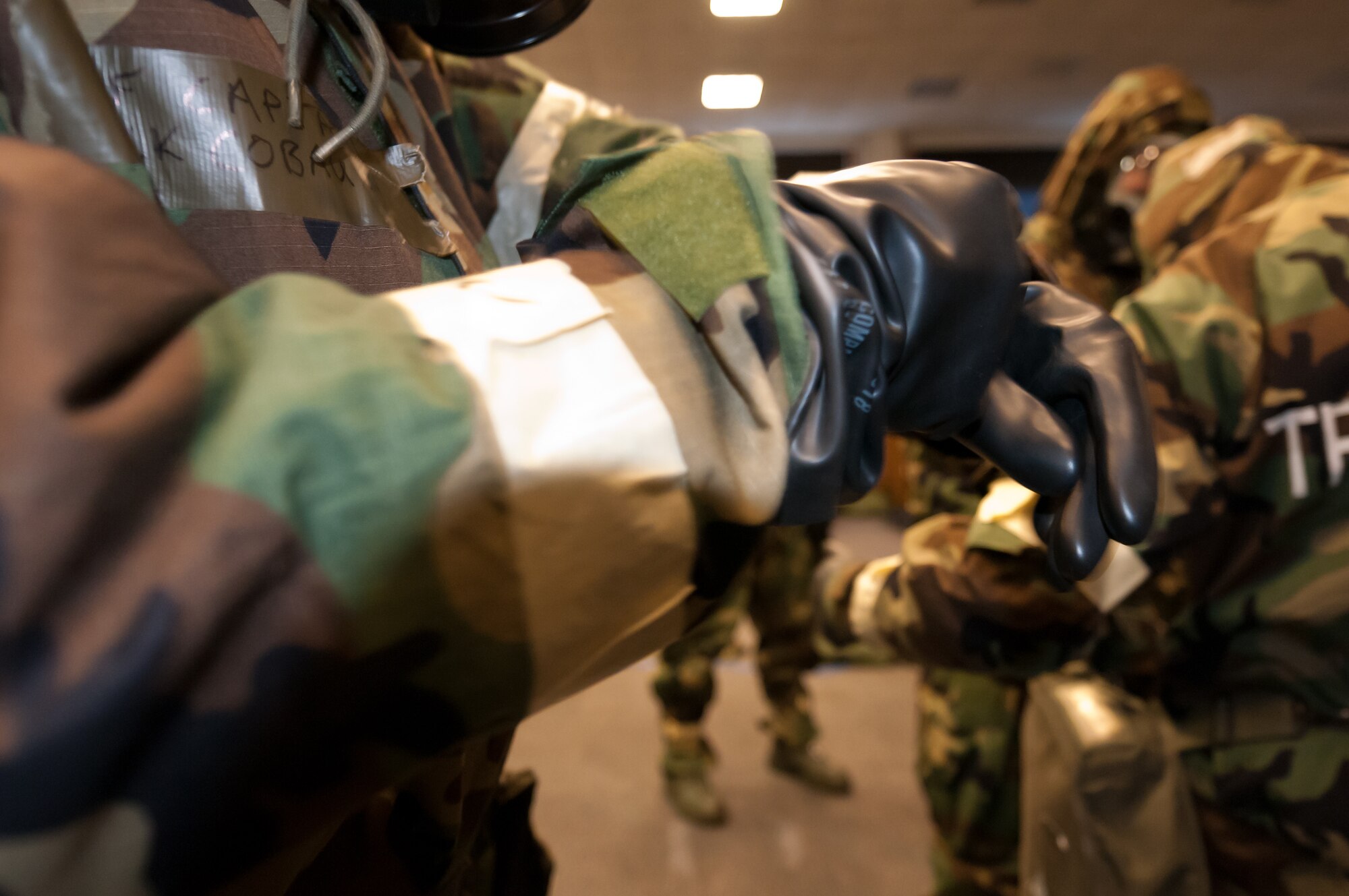 JOINT BASE ANDREWS, Md. -- Captain Cobau, 459th Air Refueling Wing secures Velcro around his gloves during Ability to Survive and Operate training here Feb. 12. Capt. Cobau performs mission oriented protective posture four drills to prepare for the Operational Readiness Exercise in March. (U.S. Air Force photo by Sophia Piellusch)

