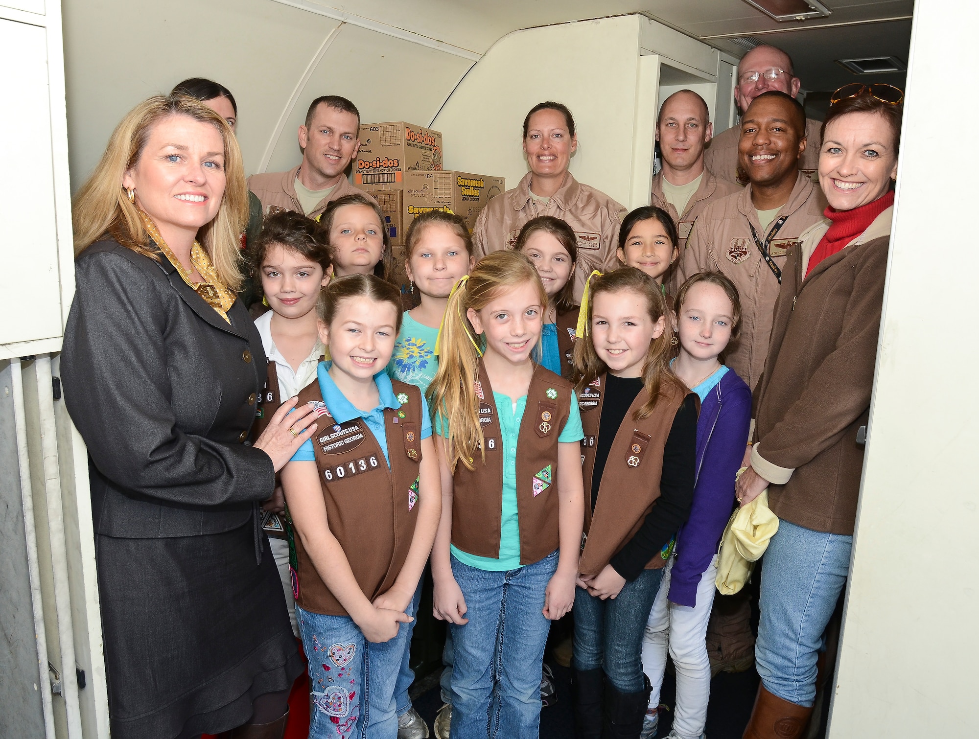 A group of Brownies and their leaders from Troop 60136, Warner Robins, Ga., pose with E-8 Joint STARS flight crew members during a tour at Robins Air Force Base, Ga., March 6, 2012.  The Brownie Troop toured the jet during a visit where they donated 129 boxes of the cookies to be delivered to deployed JSTARS members. (National Guard photo by Master Sgt. Roger Parsons/Released)