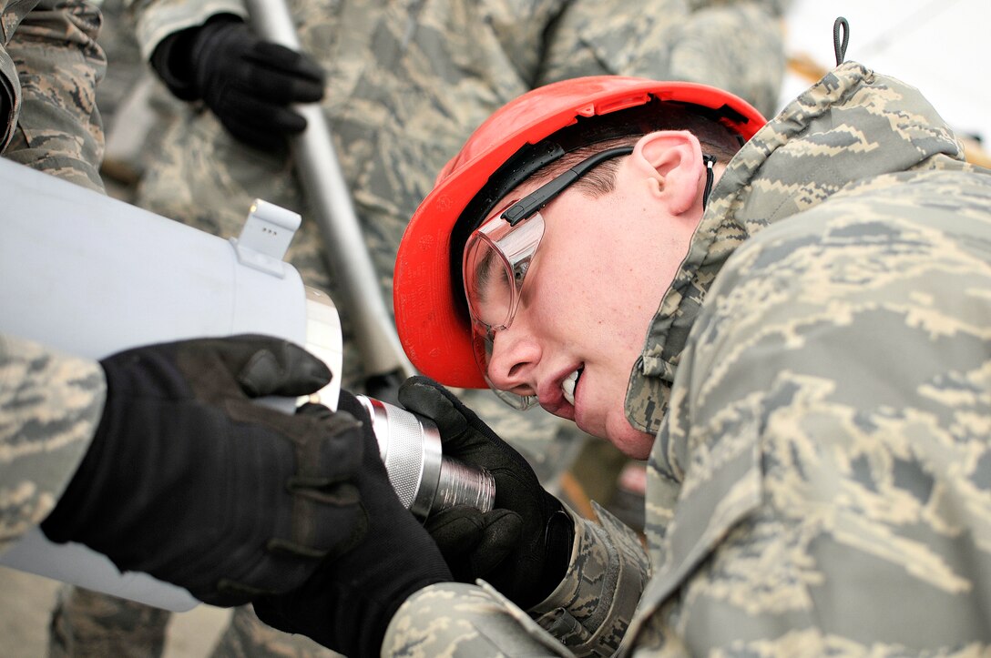 Airman 1st Class Chadd Haggenjos holds a socket in place on March 10, 2012 in Fort Wayne, Ind.  Haggenjos was using a special socket made to torque the fuse to a bomb to over 1,000 ft.lbs. of torque.  Photo by U.S. Air Force Staff Sgt. Justin Goeden (RELEASED)