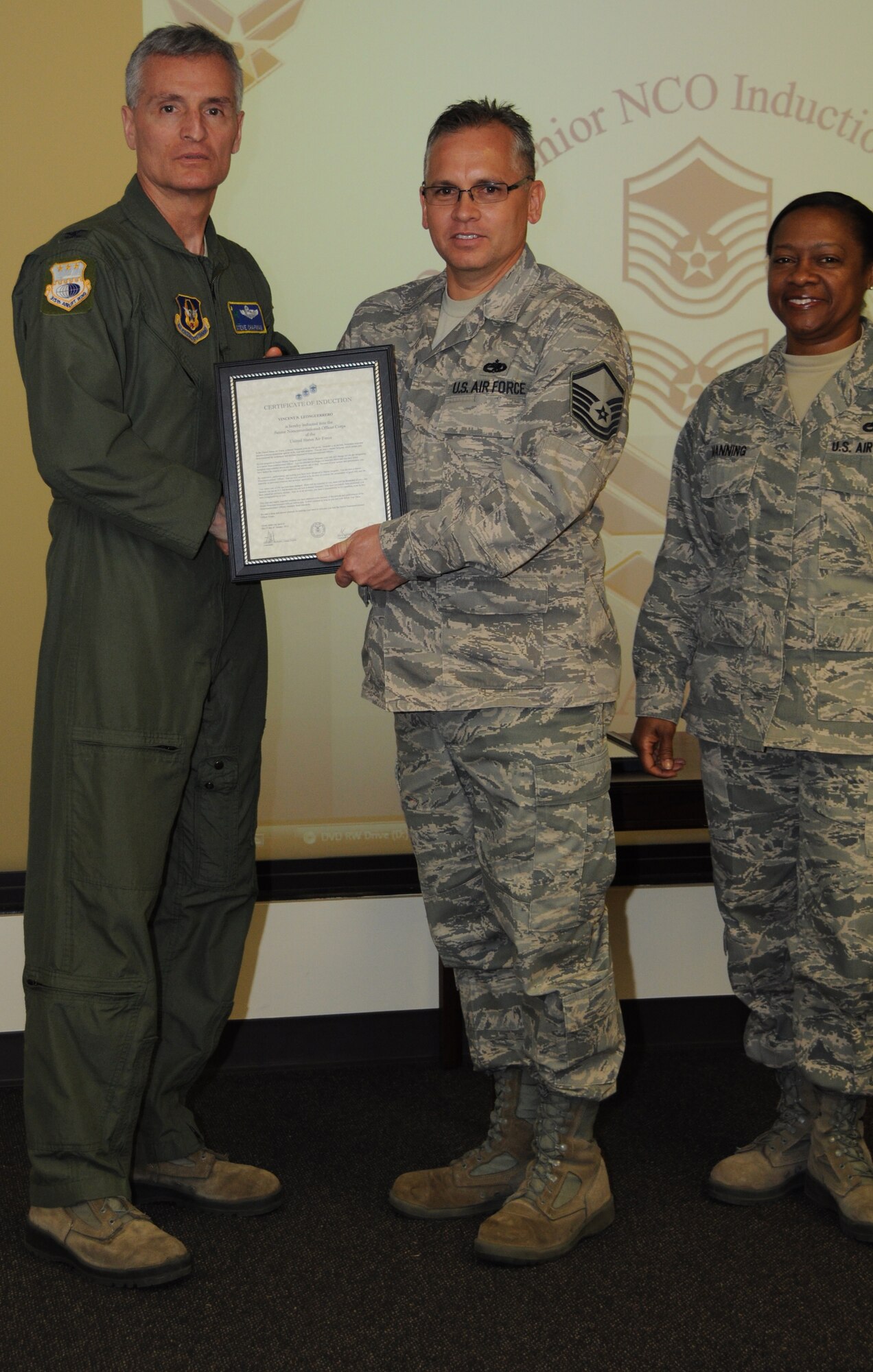 Col, Steven Chapman 315th Airift Wing Commander and Command Chief Master Sergeant Gigi Manning presided over the NCO and SNCO induction ceremony here March 10. MSgt Vincet Leonguerro recieved a coin from Command Chief Manning and a certificate from Col. Chapman. (U.S. Air Force Photo/SrA Bobby Pilch)