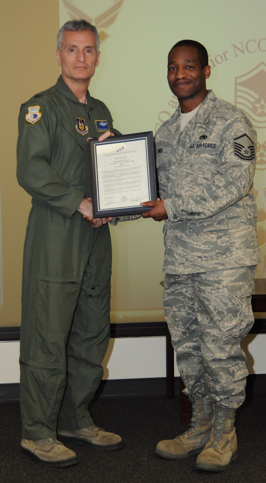 Col, Steven Chapman 315th Airift Wing Commander and Command Chief Master Sergeant Gigi Manning presided over the NCO and SNCO induction ceremony here March 10. MSgt Marcus Ford recieved a coin from Command Chief Manning and a certificate from Col. Chapman. (U.S. Air Force Photo/SrA Bobby Pilch)