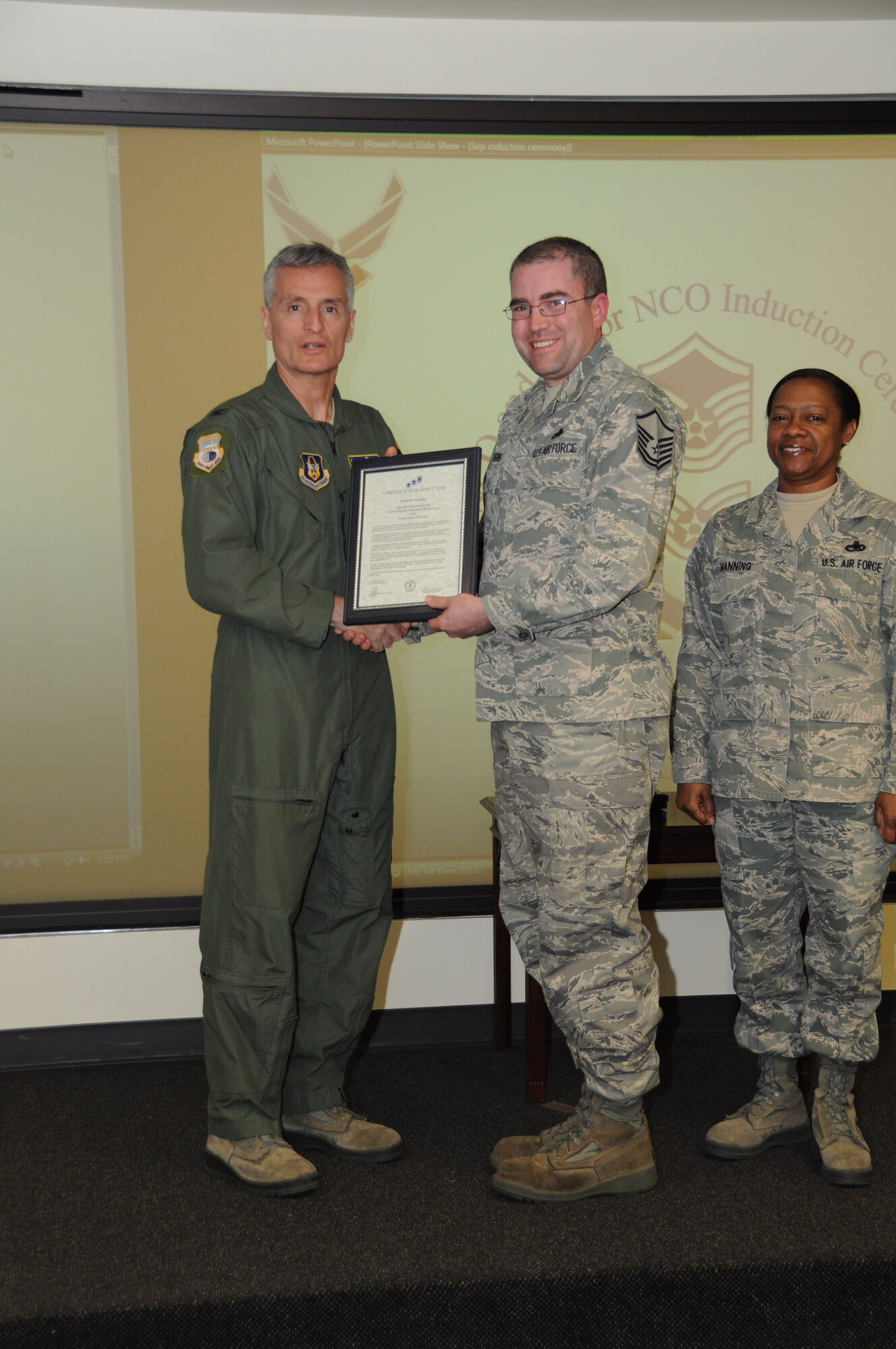 Col, Steven Chapman 315th Airift Wing Commander and Command Chief Master Sergeant Gigi Manning presided over the NCO and SNCO induction ceremony here March 10. MSgt Jason Coggins recieved a coin from Command Chief Manning and a certificate from Col. Chapman. (U.S. Air Force Photo/SrA Bobby Pilch)