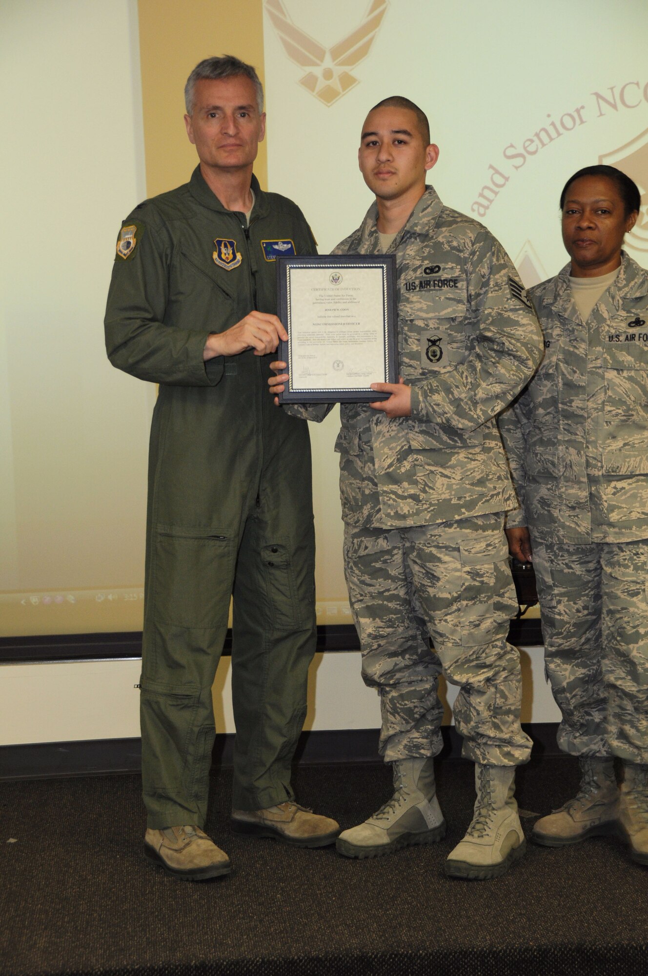 Col, Steven Chapman 315th Airift Wing Commander and Command Chief Master Sergeant Gigi Manning presided over the NCO and SNCO induction ceremony here March 10. SSgt Joseph Coon recieved a coin from Command Chief Manning and a certificate from Col. Chapman. (U.S. Air Force Photo/SrA Bobby Pilch)
