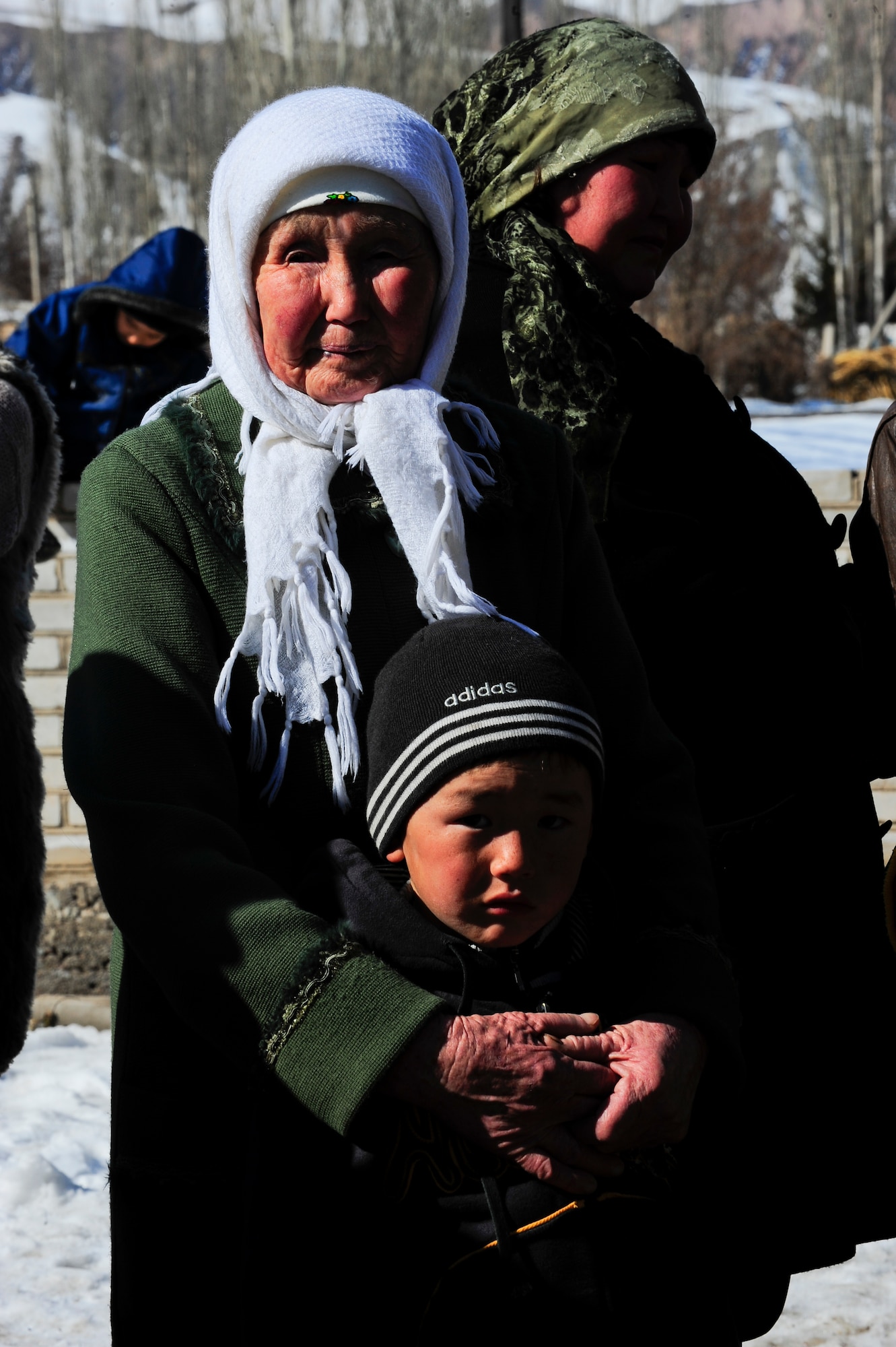 Saginbubu Kanai holds her grandson Abdybakirov Tukesh March 9, 2012, during an Operation Warm and Dry distribution at Kizil Arik village, Kyrgyzstan. This was one of the last distributions of the $300,000 humanitarian assistance project coordinated by the Transit Center at Manas. (U.S. Air Force Photo/Staff Sgt. Angela Ruiz)