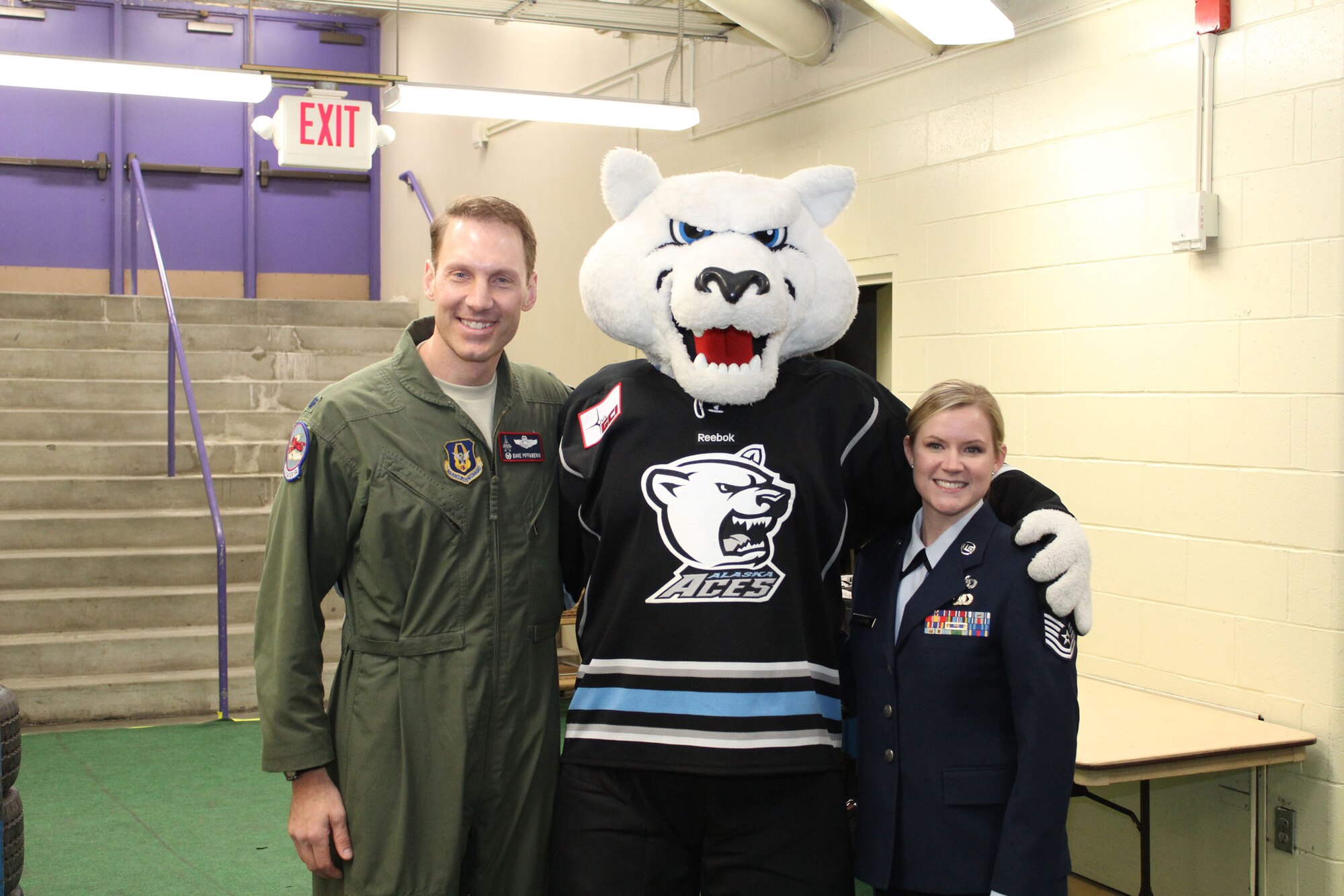 Lt. Col David Piffarerio, 302nd Fighter Squadron commander, and Tech. Sgt. Heidi Dickinson, 477th Fighter Group, pose for a photo with Boomer, the Alaska Aces mascot, before the game March 10. Piffarerio dropped the puck and Dickinson sang the national anthem before the start of the Aces last home game of the season which honored the Air Force Reserve. (U.S. Air Force/ Tech. Sgt. Dana Rosso) 