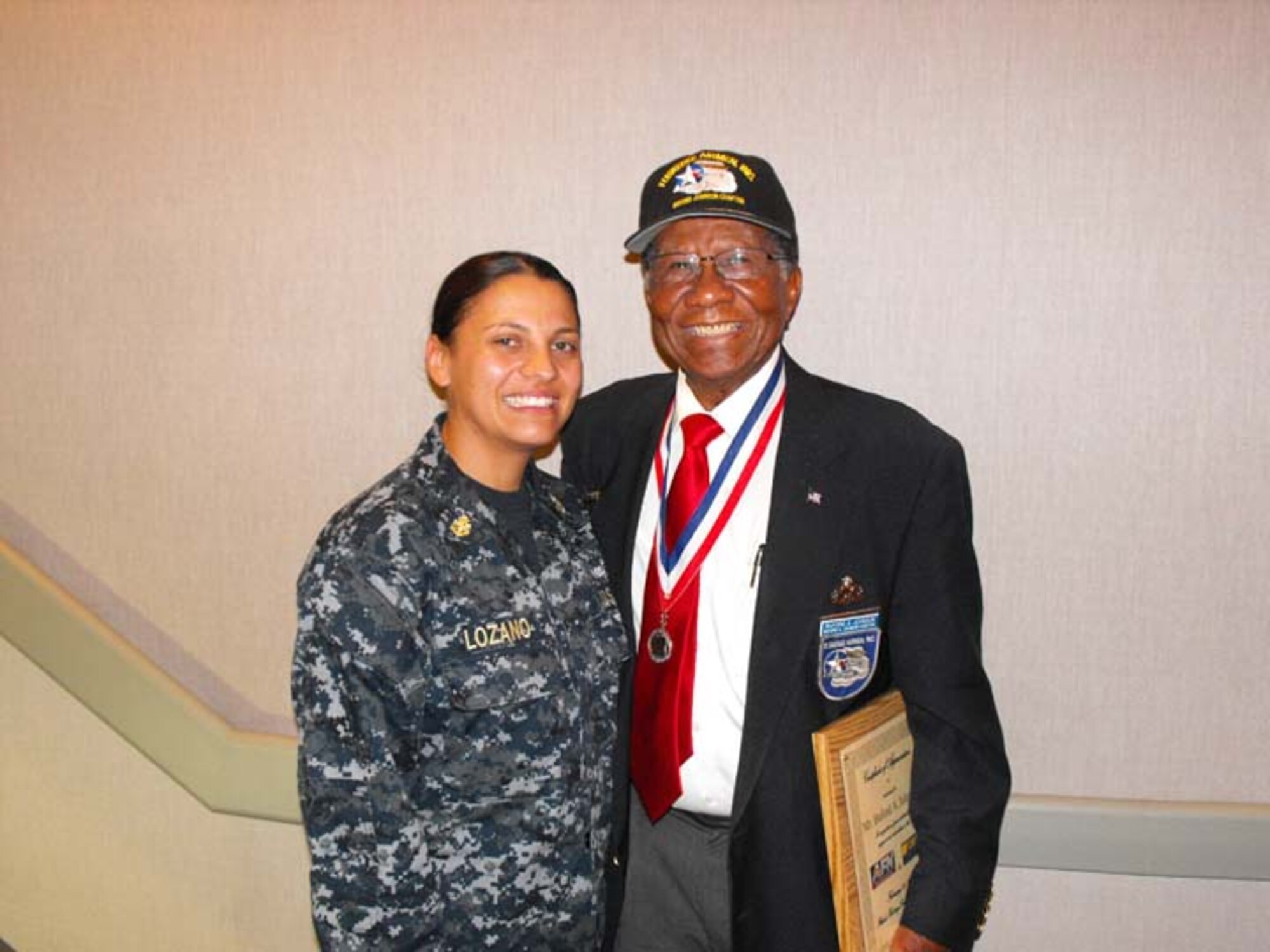 Navy Internal Communications Chief Marisela Lozano poses with retired U.S. Air Force Buford A Johnson at Defense Media Center (DMC), Riverside, Calif., Feb. 28, 2012. Lozano is a member of the install team at DMC, and Buford, who fought in World War II, is a member of the Buford A. Johnson (CA) Chapter of Tuskegee Airmen, Inc.  (Photo by Navy Mass Communication Specialist Seaman William S. Gaskill)