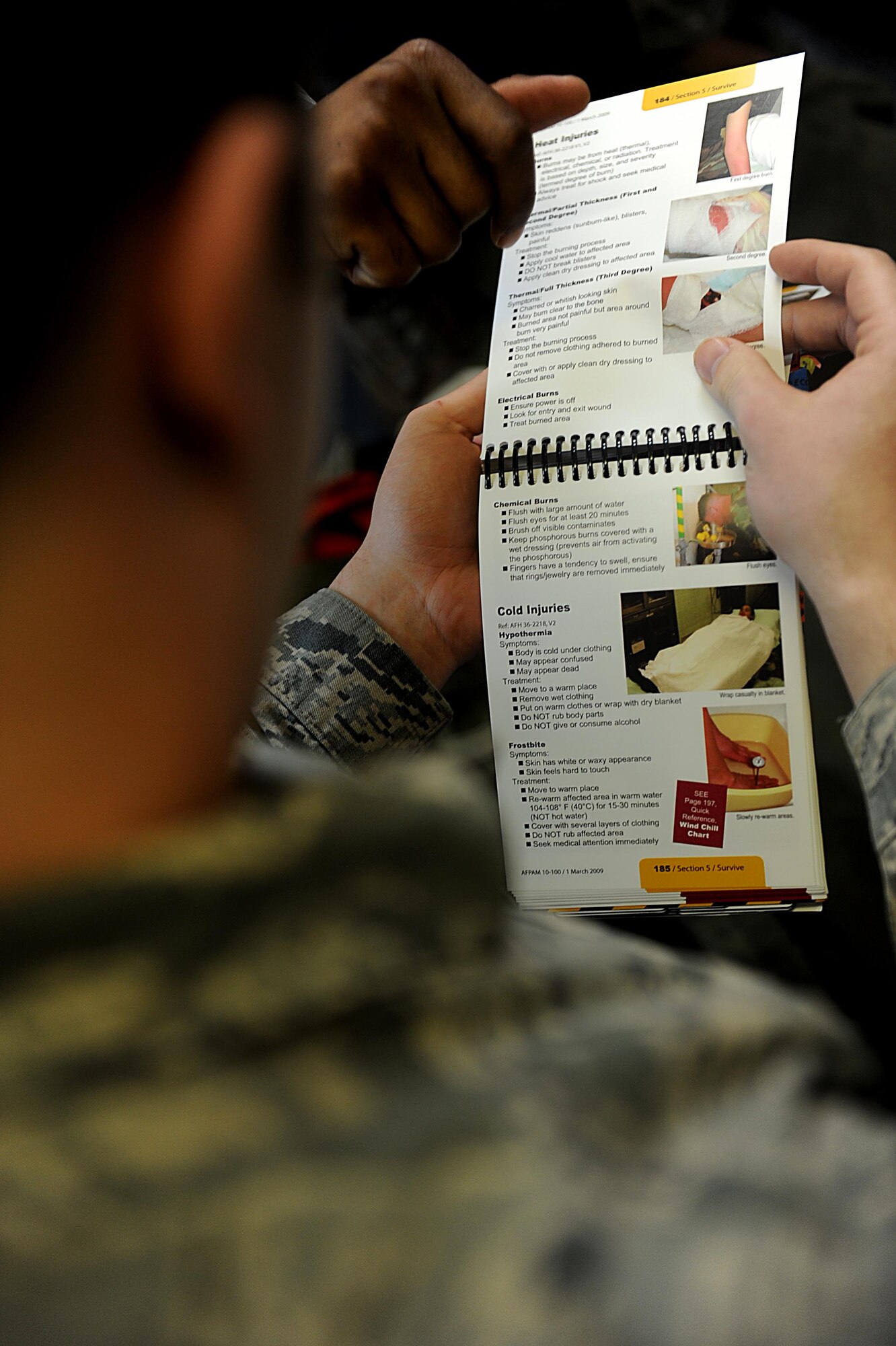 U.S. Air Force Airman 1st Class Tyler Matthew, 18th Logistics Readiness Squadron, flips through his Airman's Manuel for help during a self-aid and buddy care scenario on Kadena Air Base, March 12, 2012. Kadena is participating in Beverly High 12-3, a local operational readiness exercise, which prepares Airmen for real world contingencies. (U.S. Air Force photo by Airman 1st Class Brooke P. Beers/Released)