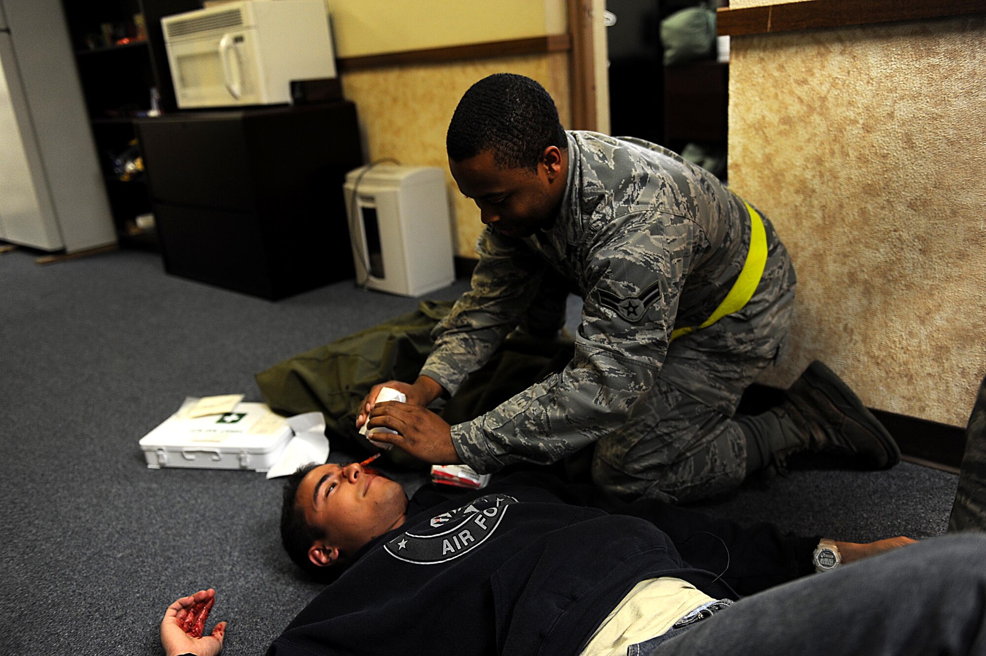 U.S. Air Force Airman 1st Class Charlie Graham, 18th Logistics Readiness Squadron, provides self-aid and buddy care during local operational readiness exercise Beverly High 12-3 at Kadena Air Base, March 12, 2012. Moulage adds realism during the exercise, and LOREs give Airmen the opportunity to train in a safe environment and prepare for real world contingencies. (U.S. Air Force photo by Airman 1st Class Brooke P. Beers/Released).  