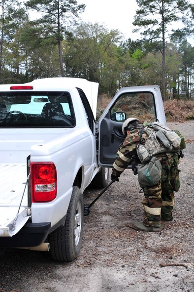 U.S. Air Force Airman 1st Class Angelina Jones, 23d Security Forces Squadron fire team member, looks under a vehicle for suspicious packages during a phase II operational readiness exercise at Moody Air Force Base, Ga., March 7, 2012. SFS remained vigilant by performing routine vehicle checks prior to entering the field training exercise site to help prevent an attack. (U.S. Air Force photo by Staff Sgt. Stephanie Mancha/Released)
