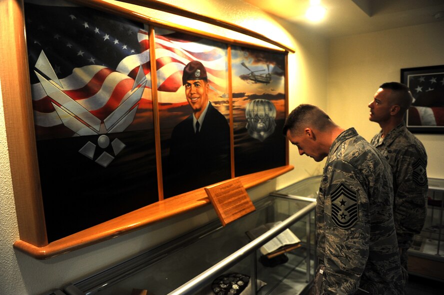 U.S. Air Force Chief Master Sgt. Douglas McIntyre, 5th Air Force command chief, reads background information on a painting with Chief Master Sgt. Mark Marson, 18th Wing command chief, during a tour of the McDaniel Center on Kadena Air Base, Japan, March 9, 2012.The McDaniel Center is named after Master Sgt. William McDaniel, a pararescueman who was assigned to the 320th Special Tactics Squadron, who died in an MH-47E helicopter crash on Feb. 22, 2002, during a training exercise in the Philippines. (U.S. Air Force photo/Airman 1st Class Justin Veazie/Released)