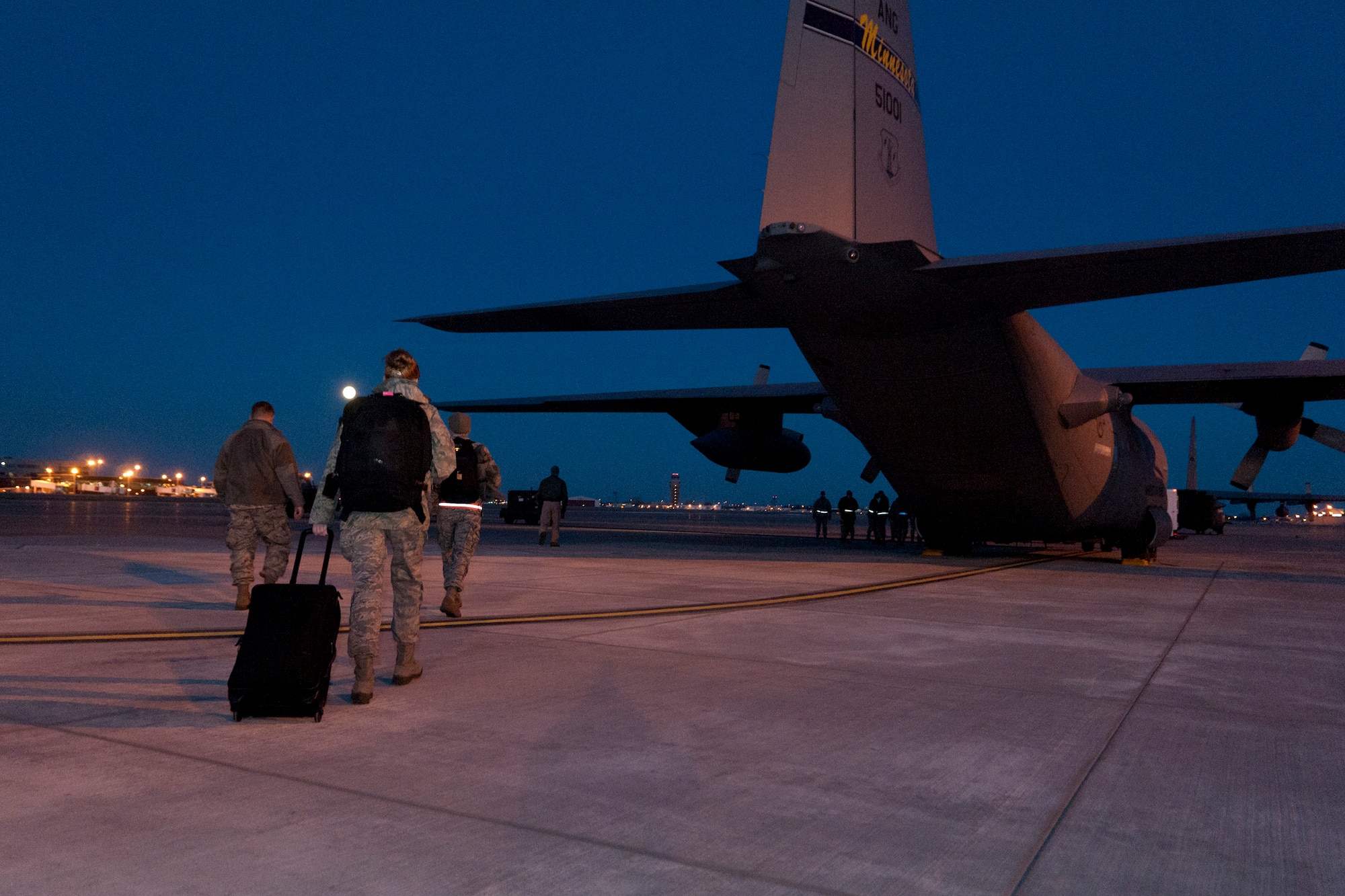 Airmen from the 133rd Airlift Wing, Minnesota Air National Guard, walk with the moon overhead in the early morning hours of March 9, 2012 towards a waiting C-130 H3 “Hercules” that will transport them and about 30 others to Afghanistan in support of Operation Enduring Freedom at the St. Paul Air National Guard base. USAF official photo by Senior Airman Jonathan Young