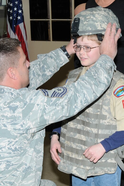 131 SMSgt Ron Mines of the 910 Security Forces assists a member of Boy Scout Troop 99 out of Newberry, Ohio, in putting on a flak vest and helmet.
