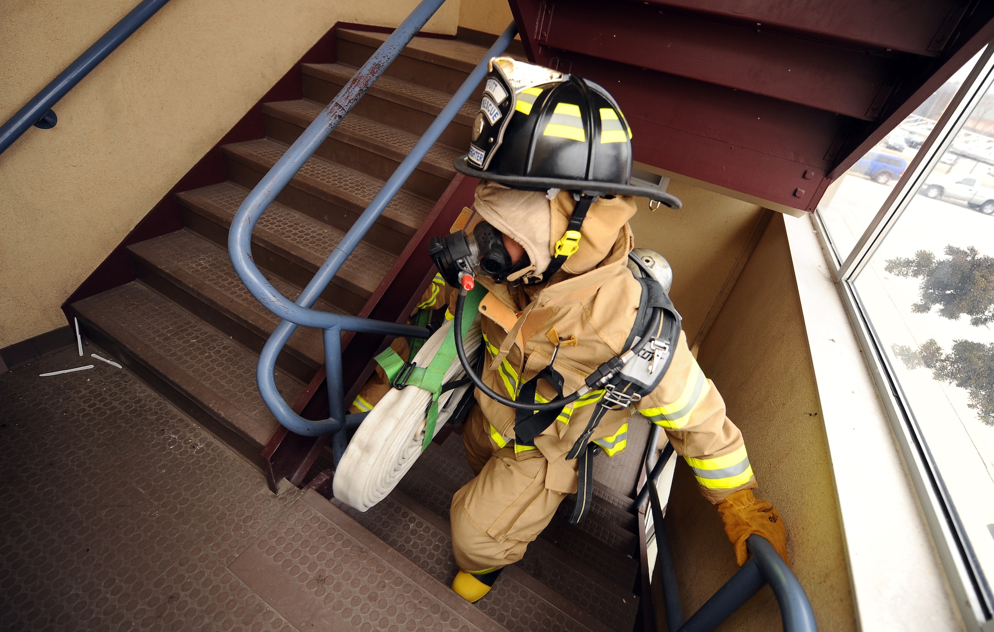 U.S. Air Force Brig. Gen. Donald Bacon, 55th Wing commander, carries the fire hose to the second floor of the now empty McCoy Hall dormitories while training with firefighters at Offutt Air Force Base, Neb., March 7.  Bacon spent a 24-hour period with Offutt's firefighters to get an up-close look into their operations and life in the firehouse.  (U.S. Air Force photo by Josh Plueger/Released).