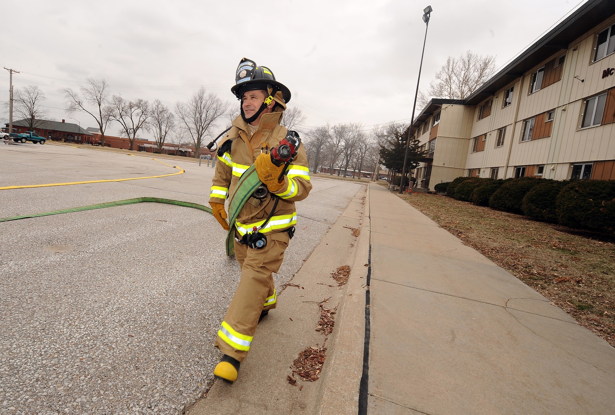 U.S. Air Force Brig. Gen. Donald Bacon, 55th Wing commander, takes an unraveled hose from a fire truck prior to entering McCoy Hall, a former dorm building, to experience what it looks like to enter a burning building to find survivors on Offutt Air Force Base, Neb., March 7.  Smoke machines turned hallways into opaque walls of gray as Bacon made his way through the building to find "dummies" representing real people.  (U.S. Air Force photo by Josh Plueger/Released).