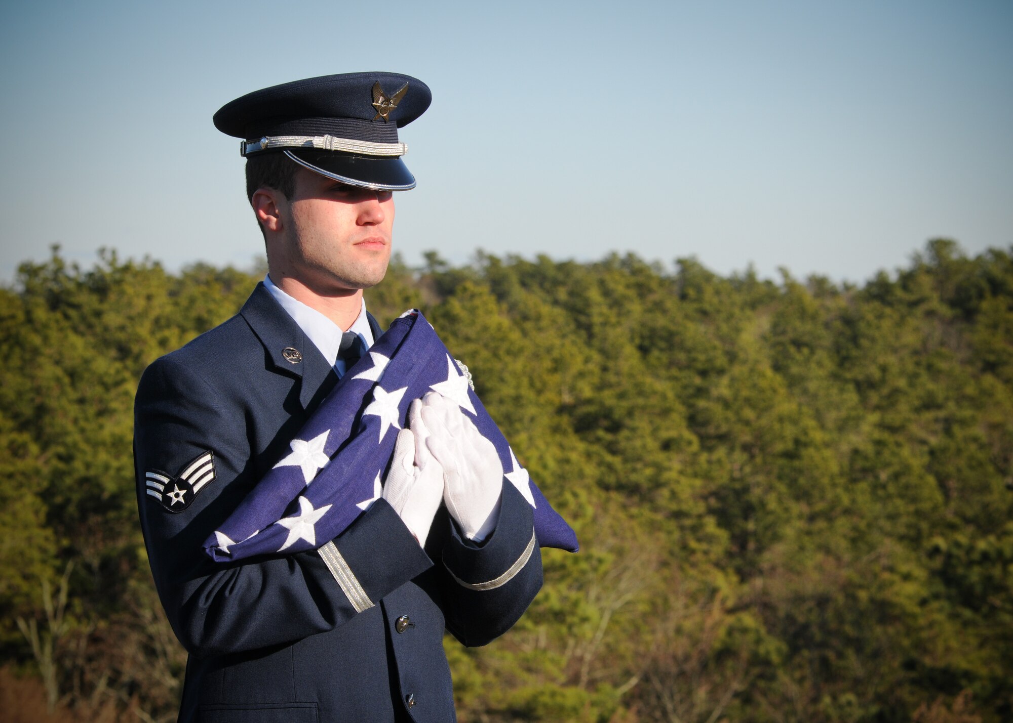 Senior Airman Zackery Benton of the 102nd Honor Guard prepares to unfold a flag in honor of a fallen veteran at the Bourne National Cemetery Jan. 19. (National Guard photo by Tech. Sgt. Kerri Cole/Released)