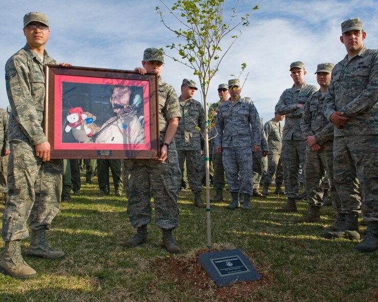 U.S. Air Force Airman 1st Class Marcus Cortez, left, and Senior Airman Elizabeth Patton, right, hold a photo of Tech. Sgt. Joey Link, 39th Airlift Squadron, during a memorial service March 7, 2012, at Dyess Air Force Base, Texas. A memorial service was held for Tech. Sgt. Link who died of natural causes during a deployment in Southwest Asia. (U.S. Air Force photo by Airman 1st Class Jonathan Stefanko/ Released)
