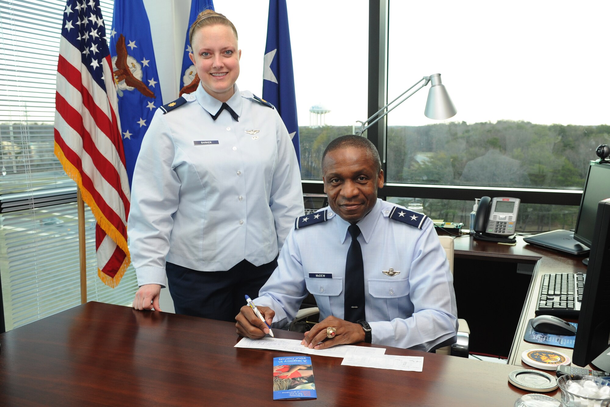 Maj. Michelle Barker, Air Force Assistance Fund lead project officer, assists Air Force District of Washington Commander Maj. Gen. Darren W. McDew in contributing to the 2012 campaign. AFDW will have the opportunity to give from March 12 through April 20. "What is special about this campaign, what makes it different than all the rest, is that it directly gives back to our people," said Barker. (U.S. Air Force photo by Tech. Sgt. Raymond Mills) 