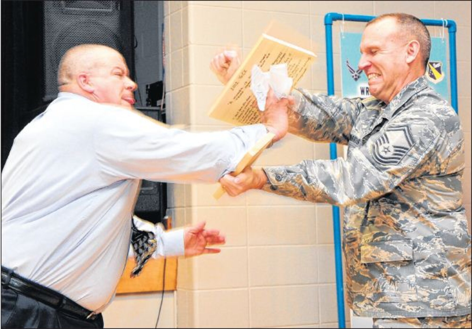 Keith Tickle, Human Resources specialist in Workforce Development, breaks a board of excuses held by Senior Master Sgt. John Parris during the “Year of Continuing Education” kickoff event March 2, 2012, at Wright-Patterson Air Force Base, Ohio. (Skywrighter photo/Niki Jahns)