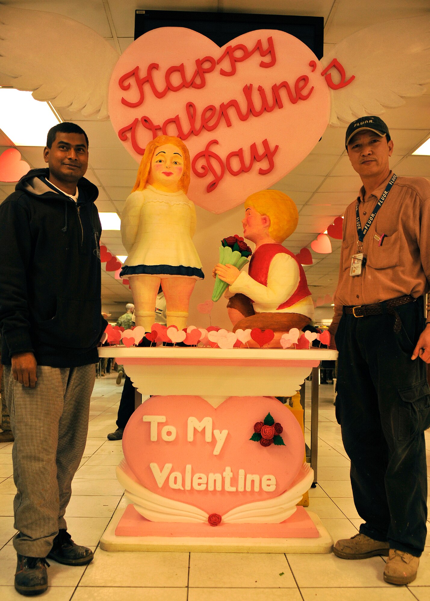 BAGRAM AIRFIELD, Afghanistan-- Euigang Jung and Halder Biswajit stand in front of their joint creation at Bagram Airfield, Afghanistan, Feb. 14, 2012. Jung and Biswajit are decoration designers with Fluor, a service and construction engineering company, and create decorations at the Dragon Dining Facility using collected packing styrofaom. (U.S. Air Force photo/Airman 1st Class Ericka Engblom)