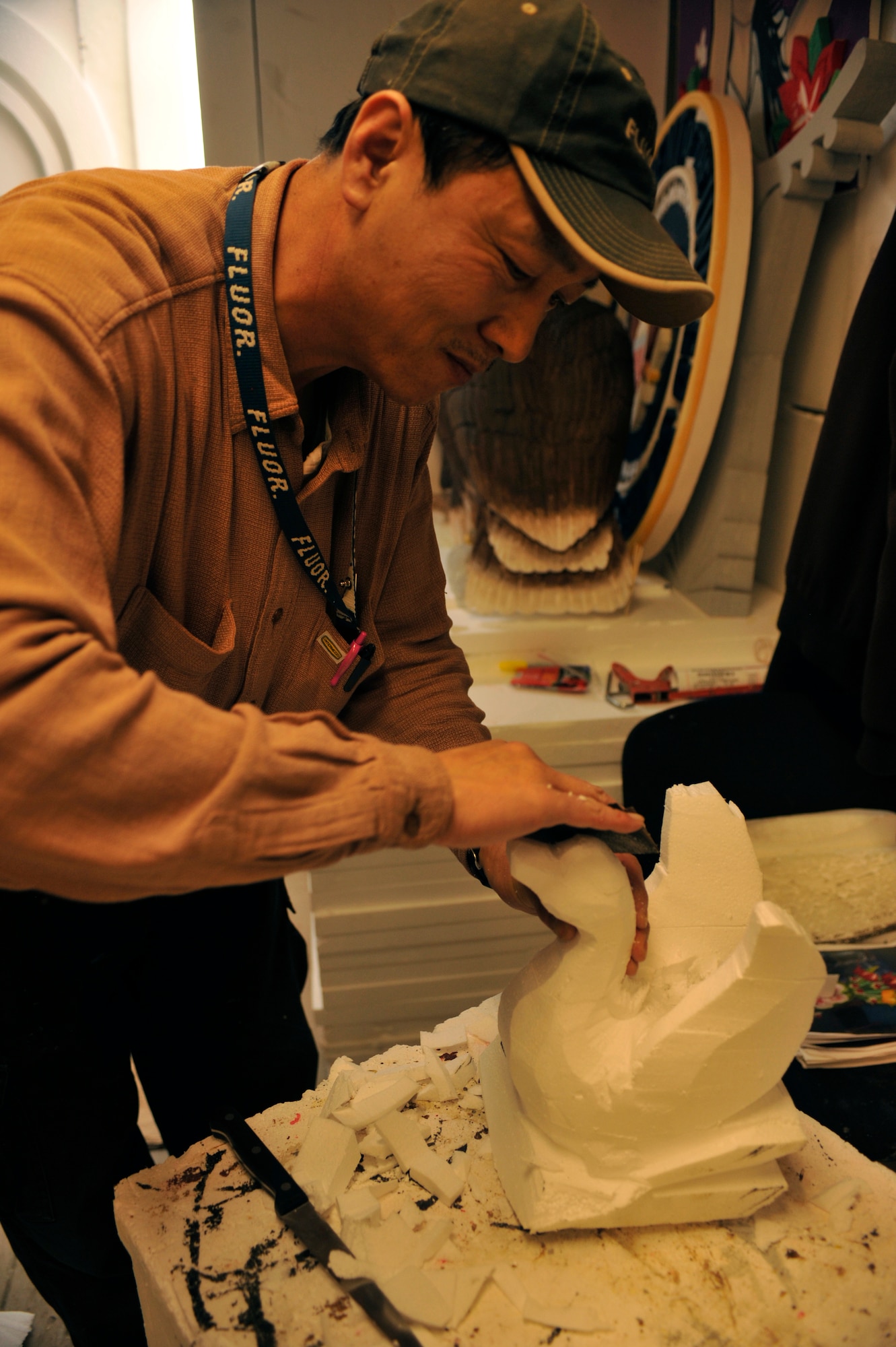 BAGRAM AIRFIELD, Afghanistan-- Euigang Jung sands down a styrofoam swan at Bagram Airfield, Afghanistan, Feb. 14, 2012. Jung is a decoration designer with Fluor, a service and construction engineering company, and creates decorations at the Dragon Dining Facility out of recycled styrofoam. (U.S. Air Force photo/Airman 1st Class Ericka Engblom)

