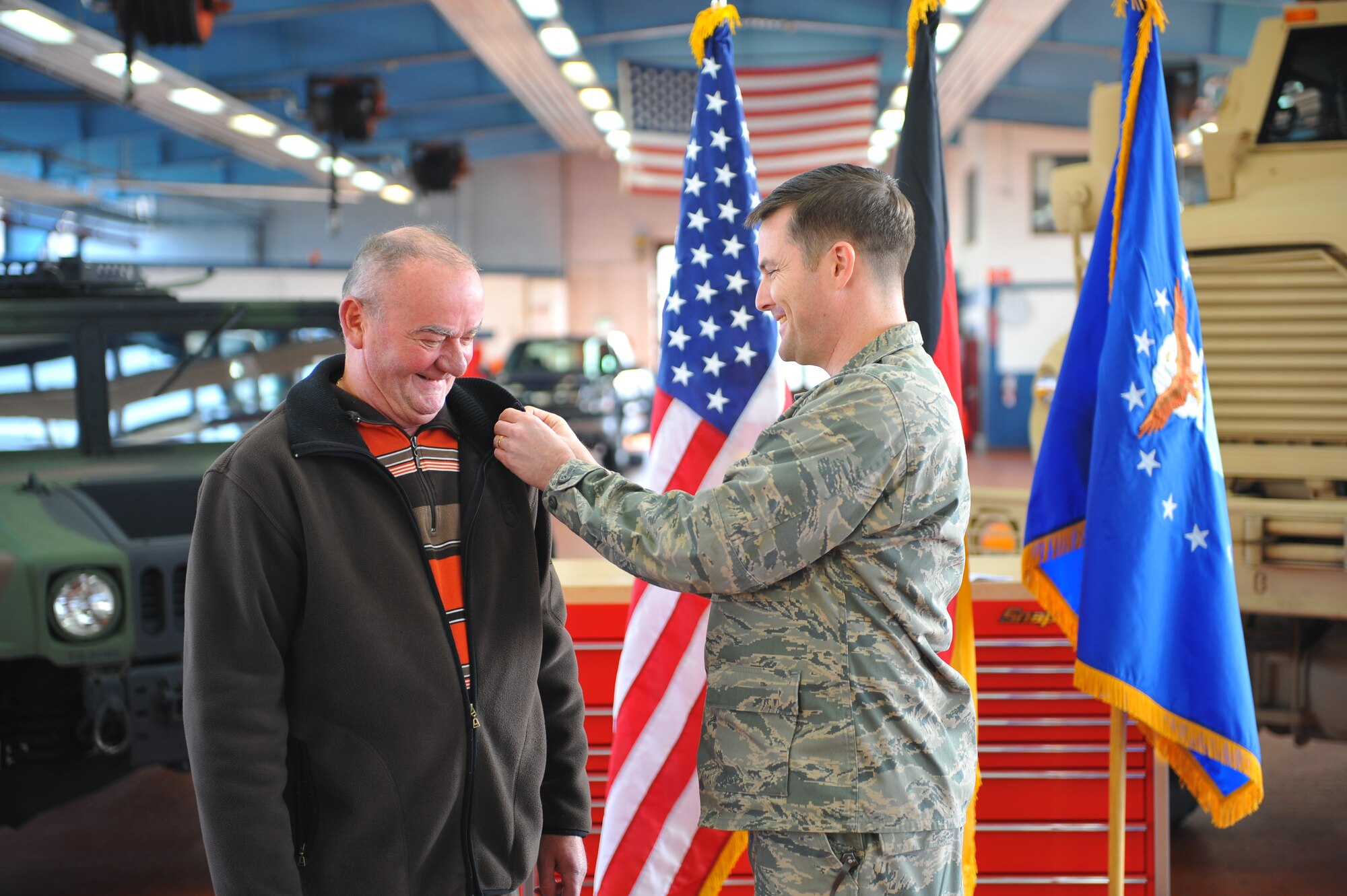 SPANGDAHLEM AIR BASE, Germany – Lt. Col. Jason Nulton, 52nd Logistics Readiness Squadron commander, places a civilian length of service pin on Mr. Hans Schinhofer, 52nd LRS lead vehicle operator, during a pinning ceremony inside Bldg. 110 here March 9. The ceremony honored Schinhofer for his 35 years of service to Spangdahlem AB. Distinguished visitor Chief Master Sgt. Billy Davis, vehicle operations career field manager, took time to participate in the ceremony, as well as to discuss upcoming changes in the career field and answer questions. (U.S. Air Force photo by Airman 1st Class Dillon Davis/Released)