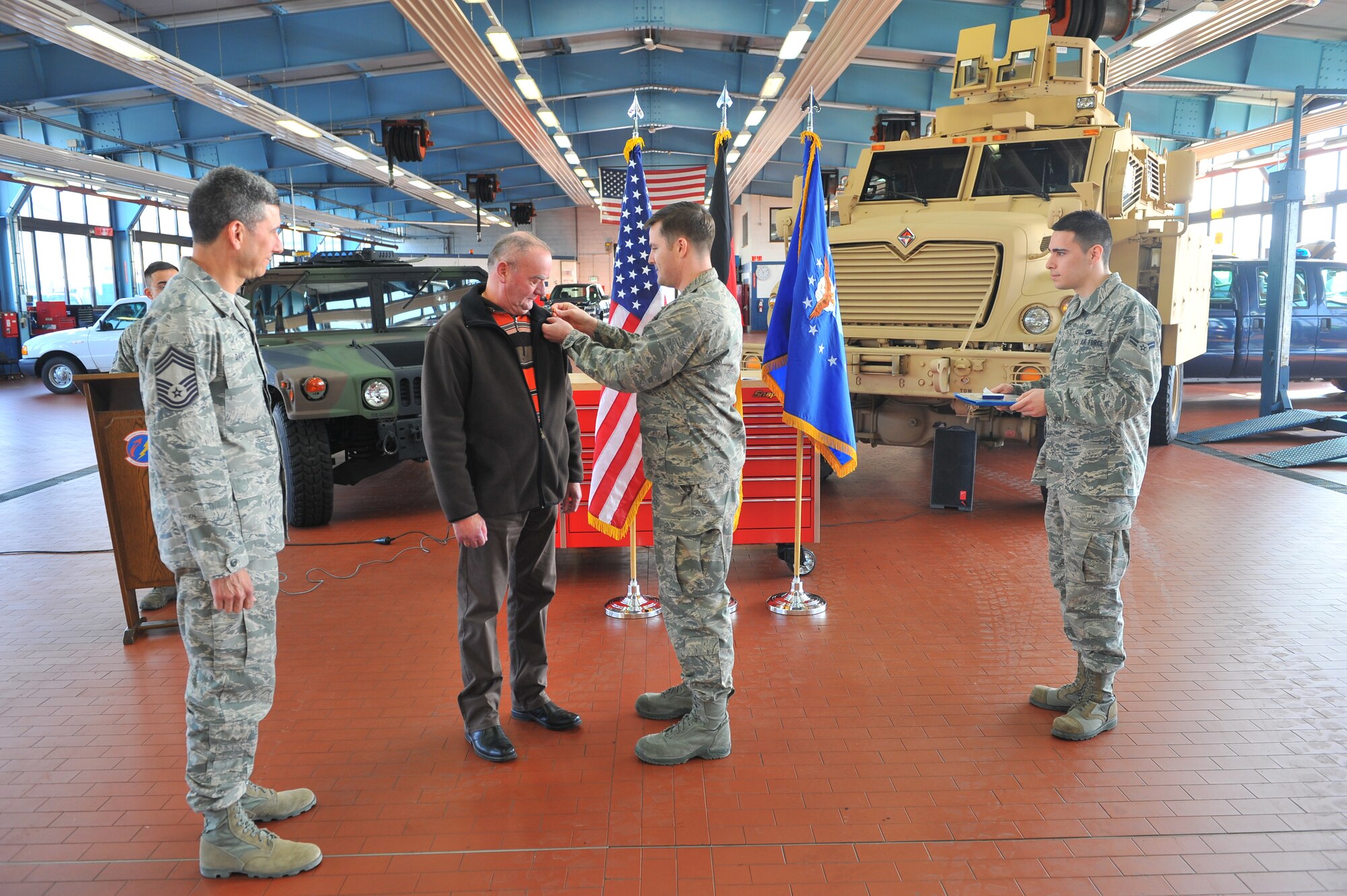 SPANGDAHLEM AIR BASE, Germany – Lt. Col. Jason Nulton, 52nd Logistics Readiness Squadron commander, places a civilian length of service pin on Mr. Hans Schinhofer, 52nd LRS lead vehicle operator, during a pinning ceremony inside Bldg. 110 here March 9. The ceremony honored Schinhofer for his 35 years of service to Spangdahlem AB. Distinguished visitor Chief Master Sgt. Billy Davis, vehicle operations career field manager, took time to participate in the ceremony, as well as to discuss upcoming changes in the career field and answer questions. (U.S. Air Force photo by Airman 1st Class Dillon Davis/Released)