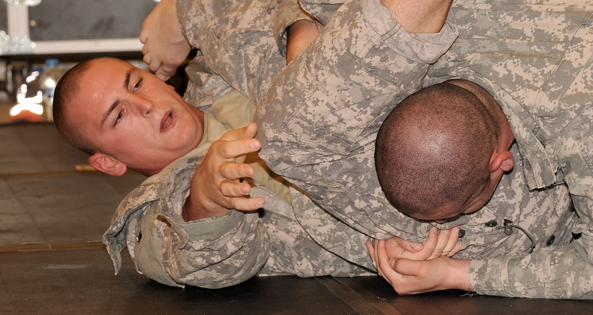 SOUTHWEST ASIA - U.S. Army Spc. Travis Miesner pins down a Soldier at the Phantom Center March 9, 2012. Airmen and Soldiers from the 380th Air Expeditionary Wing trained during a combatives course to learn 18 different self-defense techniques. At the end of 40 hours of instruction, each graduate was certified as a basic combatives instructor. Miesner is assigned to the 3rd Battalion, 4th Air Defense Artillery Regiment and is deployed from Fort Bragg, N.C. (U.S. Air Force photo/Tech. Sgt. Arian Nead)