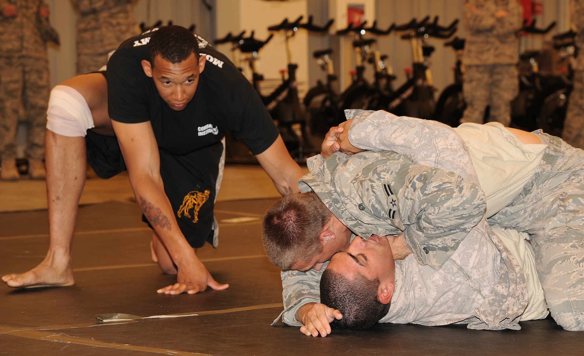 SOUTHWEST ASIA - Airman 1st Class Jonathan Dula pins down U.S. Army Spc. Alberto Romo at the Phantom Center March 9, 2012. Airmen and Soldiers from the 380th Air Expeditionary Wing trained during a combatives course to learn 18 different self-defense techniques. At the end of 40 hours of instruction, each graduate was certified as a basic combatives instructor.  Dula is assigned to the 380th Expeditionary Security Forces Squadron and is deployed from Vogelweh, Germany; Romo is assigned to the 3rd Battalion, 4th Air Defense Artillery Regiment and is deployed from Fort Bragg, N.C. (U.S. Air Force photo/Tech. Sgt. Arian Nead)