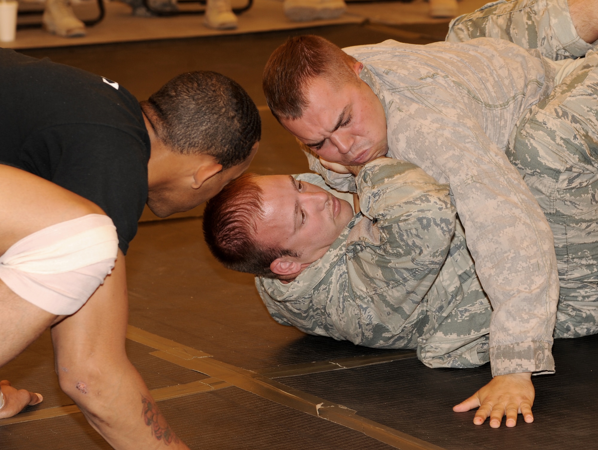 SOUTHWEST ASIA - U.S. Army Spc. Douglas Smith pins down U.S. Air Force Staff Sgt. Anthony Walling at the Phantom Center March 9, 2012. Airmen and Soldiers from the 380th Air Expeditionary Wing trained during a combatives course where at the end of 40 hours of instruction, each graduate was certified as a basic combatives instructor.  Smith is assigned to the 3rd Battalion, 4th Air Defense Artillery Regiment and is deployed from Fort Bragg, N.C. Walling is assigned to the 380th Expeditionary Civil Engineer Squadron and is deployed from Misawa Air Base, Japan. (U.S. Air Force photo/Tech. Sgt. Arian Nead)
