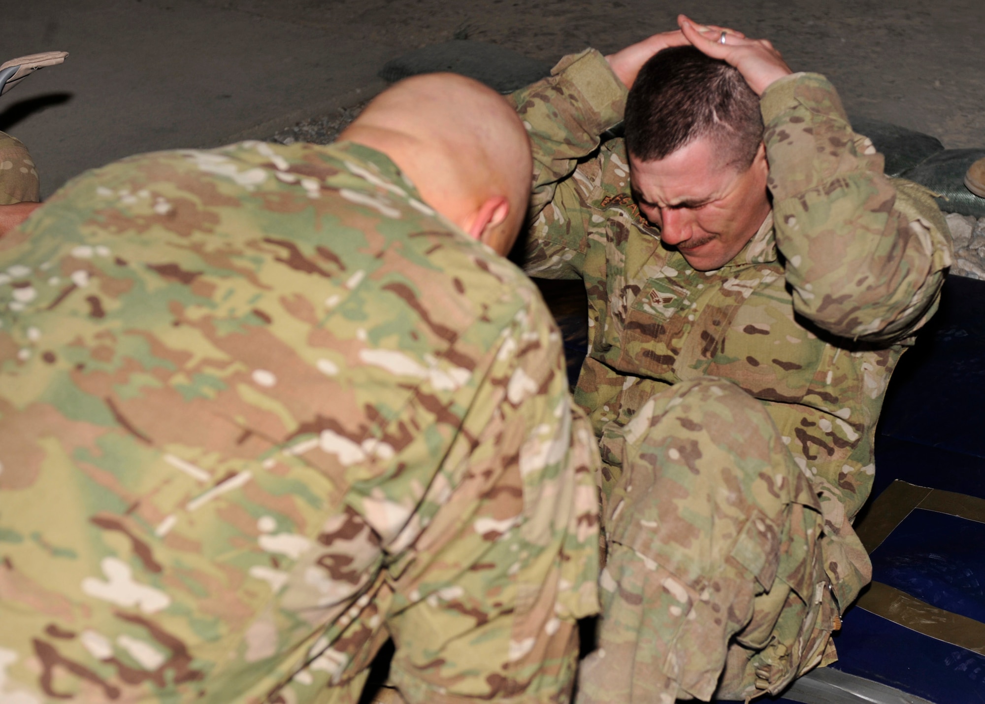 BAGRAM AIRFIELD, Afghanistan—Senior Airman Curtis Turner performs a sit up while being encouraged by Senior Airman Jonathan Bussard as part of the Combined Joint Task Force-One/Regional Command( East) Warrior Team Competition at Bagram Airfield, Afghanistan, March 10, 2012. Turner and Bussard are members of the 455th Expeditionary Security Forces Squadron and are deployed from Offut Air Force Base, Neb. They were the only Air Force members to compete in the competition. (U.S. Air Force photo/Airman 1st Class Ericka Engblom)