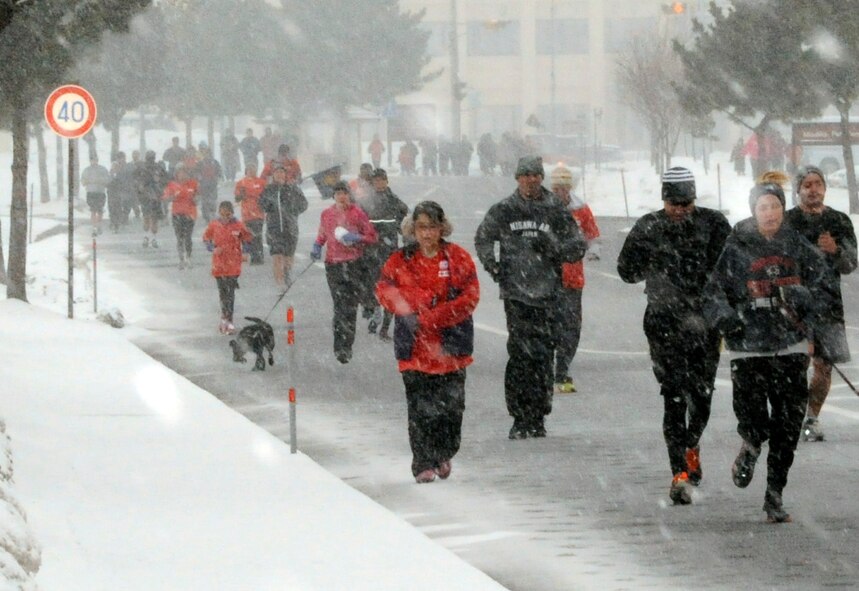 Participants run in snowy weather March 11, 2012, during the American Red Cross 5K run at Misawa Air Base, Japan, March 11, 2012. More than 300 community members ran and walked to commemorate the one year anniversary of the March 11, 2011, Japan earthquake and tsunami .(U.S. Air Force photo by Airman 1st Class Kaleb Snay/Released)