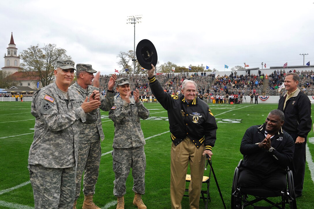 Army Chief of Staff Raymond T. Odierno, Maj. Gen. Robert B. Brown, Command Sgt. Maj. James C. Hardy and thousands of soldiers salute retired Army Lt. Gen.Harold "Hal" Moore Jr., at the annual U.S. Military Academy at West Point spring scrimmage  at Doughboy Stadium on Fort Benning, Ga., March 9, 2012.