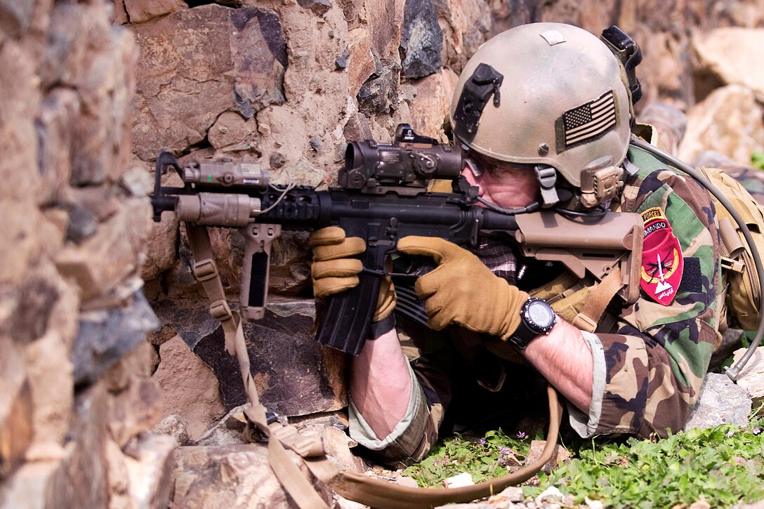 A coalition special operations forces service member defends his position from insurgent small arms fire during a firefight in the Sar Kani district of Afghanistan's Kunar province, March 7, 2012. A force of more than 100 Afghan commandos and coalition special operations forces searched an Afghan village for weapons caches and insurgents.