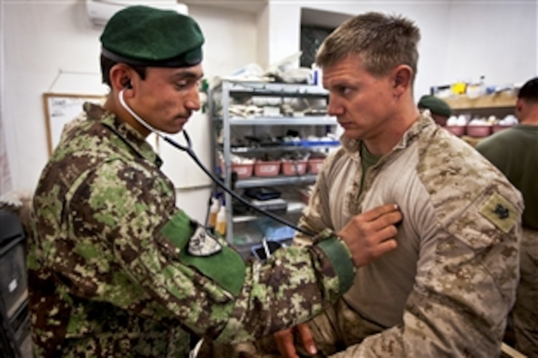 Afghan army Pvt. Samad Khan, a medic, checks the heartbeat of U.S. Navy Petty Officer 2nd Class Seth Michaelis during the final examination of an eight-week medic course for Afghan soldiers on Forward Operating Base Delhi in Afghanistan's Helmand province, March 9, 2012. Corpsmen with "America's Battalion" led the course, which was the first for Afghan soldiers in Garmsir district. Michaelis is assigned to the 3rd Battalion, 3rd Marine Regiment.