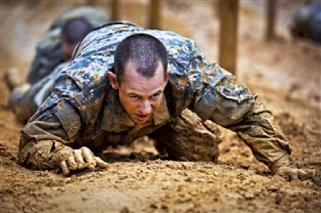Soldiers low crawl while negotiating an obstacle course during their first week of  basic combat training on Fort Benning, Ga., March 9, 2012.