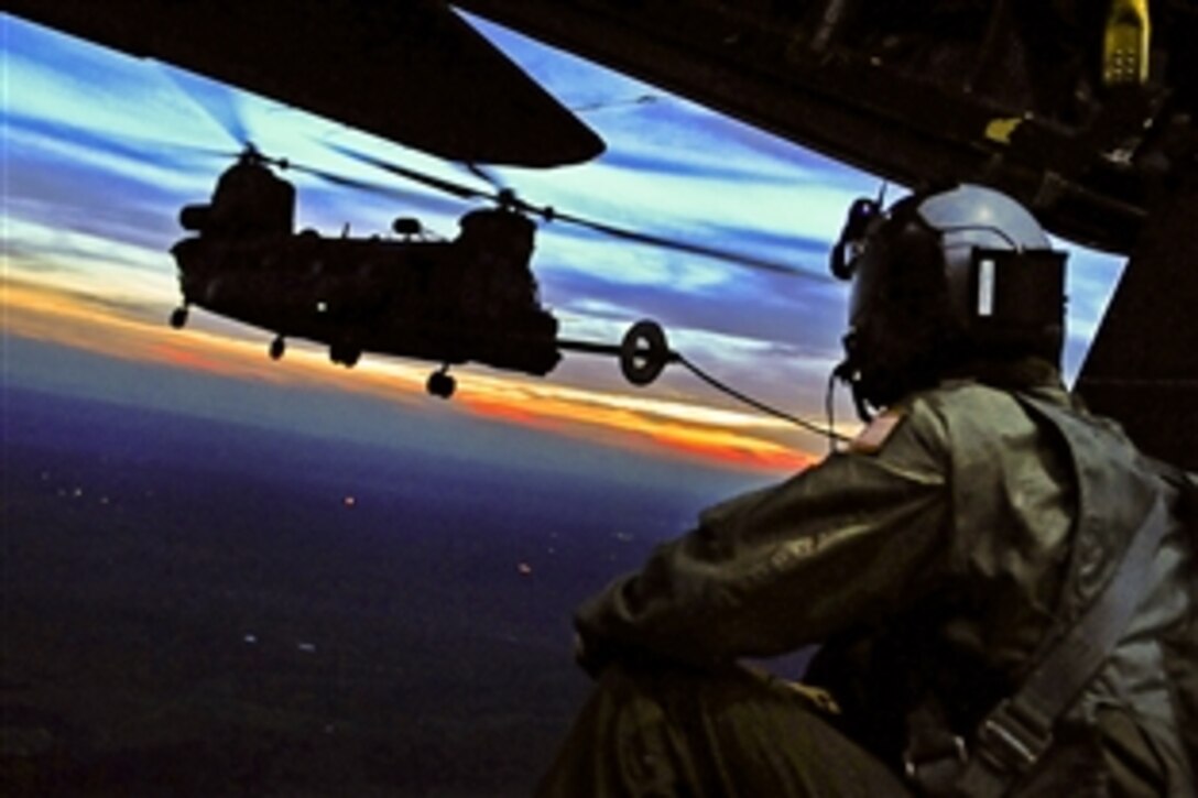An Air Force load master observes aboard a MC-130E aircraft as a CH-47 Chinook helicopter receives an aerial refueling during Emerald Warrior over Duke Field, Fla., March 6, 2012.Ritter