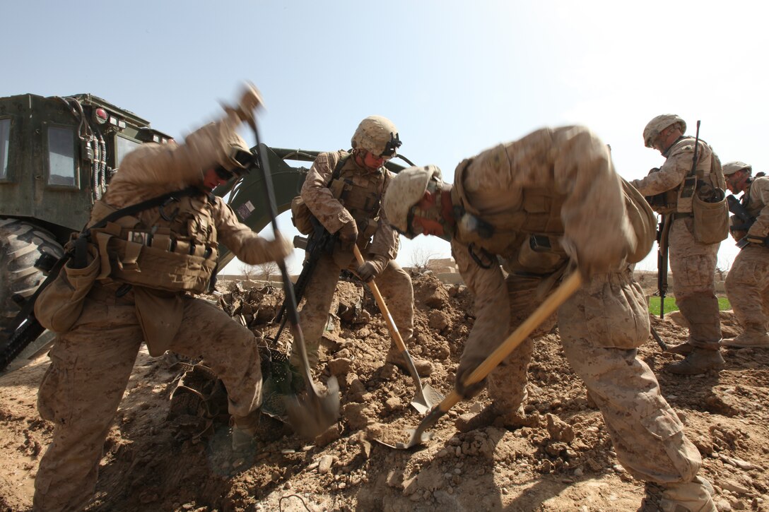 Marines with Engineer Support Company Detachment, 9th Engineer Support Battalion, 1st Marine Logistics Group (Forward) dig into the Afghan dirt during a two-day road reconstruction project along Route Yellow near Shir Ghazay, Afghanistan, March 13-14.