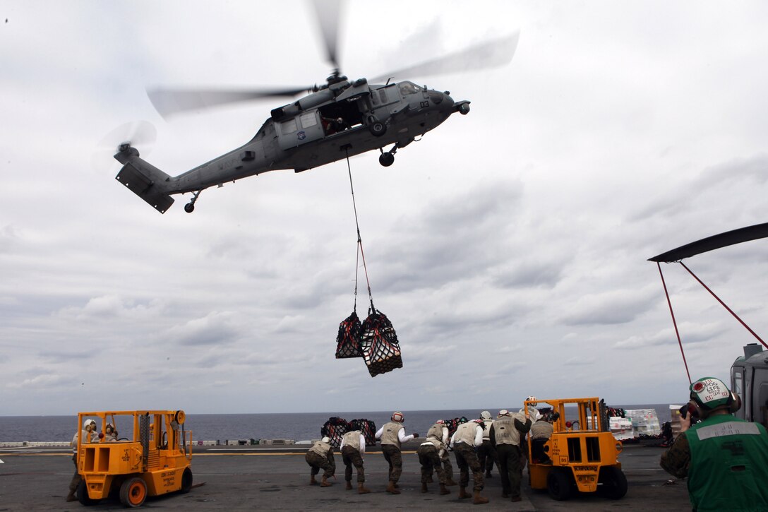 Marines with the 31st Marine Expeditionary Unit, prepare to move cargo delivered by a Navy SH-60E Seahawk helicopter, during a resupply at sea, March 13. The 31st MEU is conducting its Certification Exercise, which certifies the MEU to perform actual contingency operations during its upcoming deployment. The 31st MEU is the only continuously forward-deployed MEU and remains the nation’s force in readiness in the Asia-Pacific region.