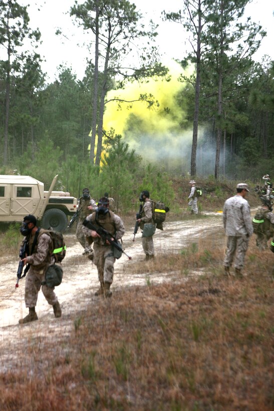 Marines with 2nd Maintenance Battalion, 2nd Marine Logistics Group provide security during a simulated attack while competing in a squad event aboard Camp Lejeune, N.C., March 13, 2012. The attack included gas and smoke, while the Marines had to implement security perimeters and evacuate simulated casualties.  (U.S. Marine Corps photo by Cpl. Katherine M. Solano)