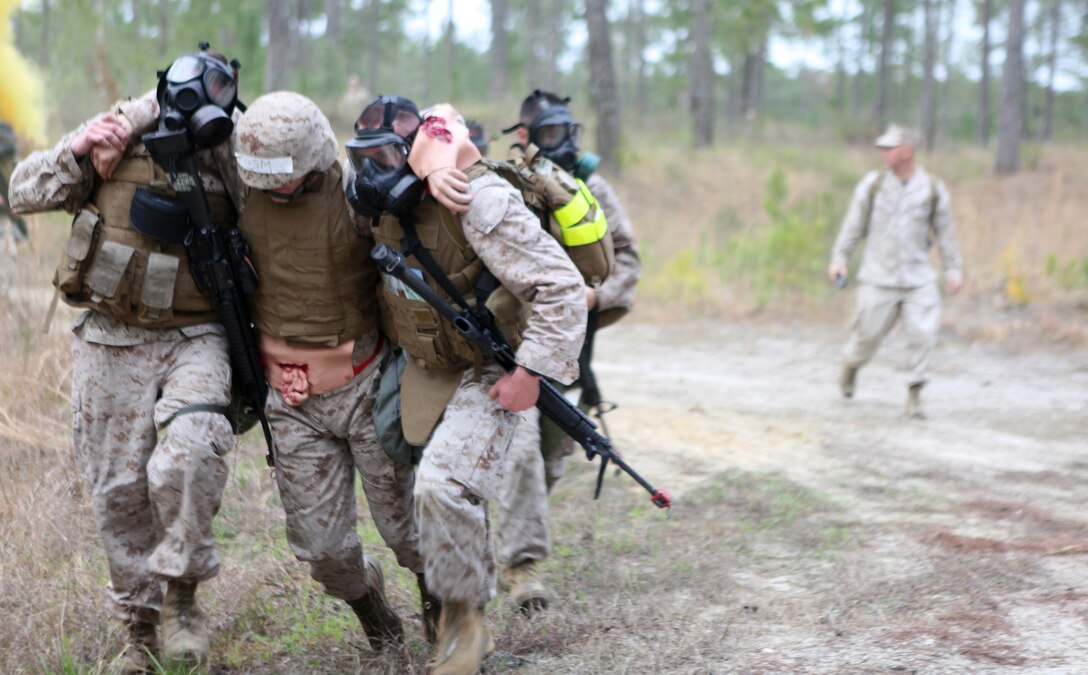 Marines with 2nd Maintenance Battalion, 2nd Marine Logistics Group assist a simulated casualty during an evacuation drill aboard Camp Lejeune, N.C., March 13, 2012. The training was part of a super squad competition in which Marines practiced combat lifesaver skills, weapons assembly and other basic Marine Corps skills.  (U.S. Marine Corps photo by Cpl. Katherine M. Solano)