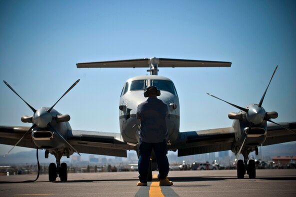 Donald Brown, L-3 Communications aircraft mechanic, prepares to marshal out an MC-12 Liberty during Red Flag 12-3, March 13, 2012 at Nellis Air Force Base, Nev. The MC-12 participated in a Red Flag for the first time during this exercise. (U.S. Air Force photo by Senior Airman Brett Clashman)