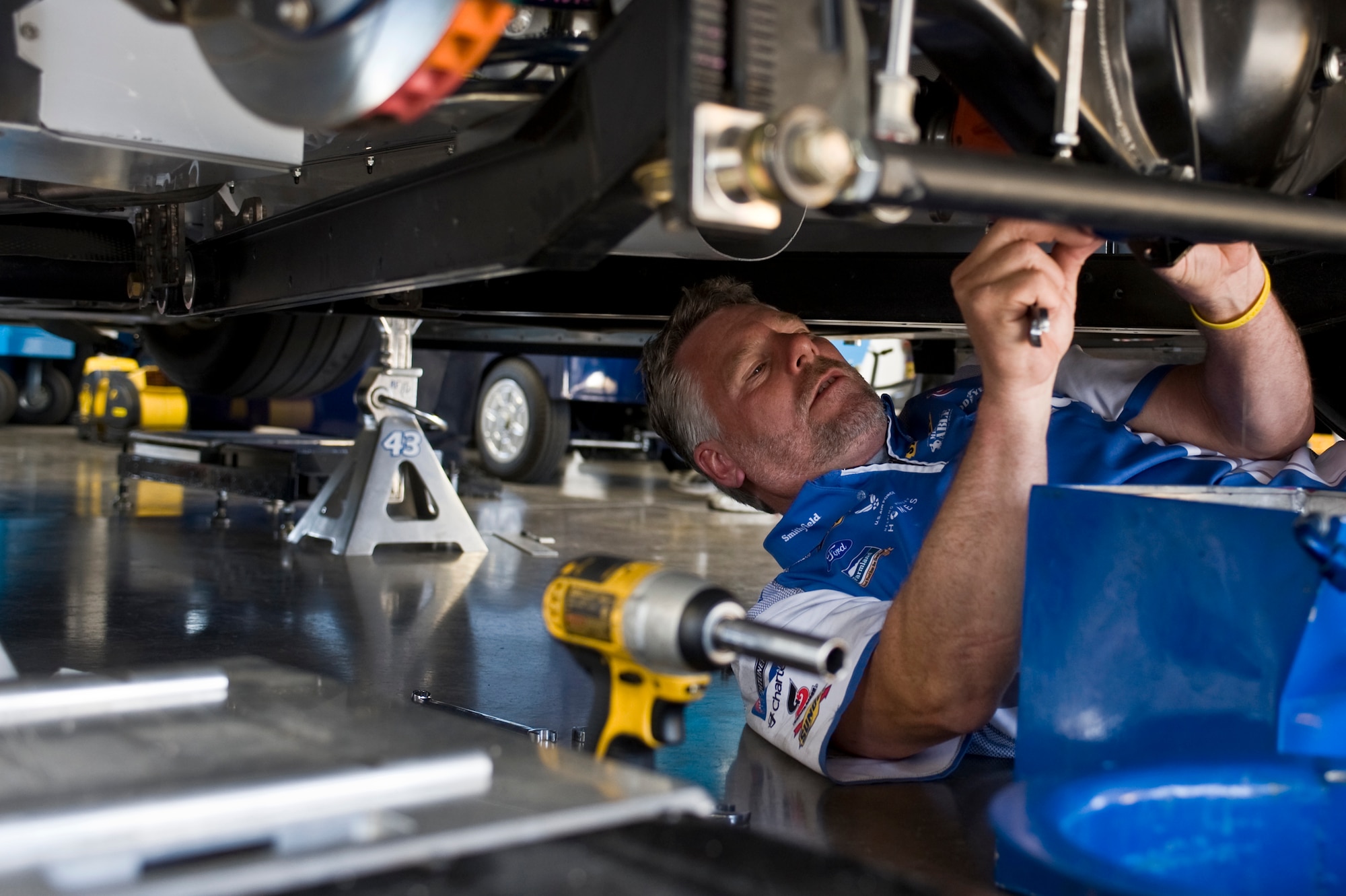 David Doyle, underneath mechanic, performs final adjustments on the Air Force-sponsored No. 43 car prior to the start of the Sprint Cup Series Race at the Las Vegas Motor Speedway qualifying round March 9, 2012, in Las Vegas. The driver, Aric Almirola, competed in the NASCAR Sprint Cup Kobalt Tools 400 Sunday at the Las Vegas Motor Speedway. (U.S. Air Force photo by Airman 1st Class Daniel Hughes)
