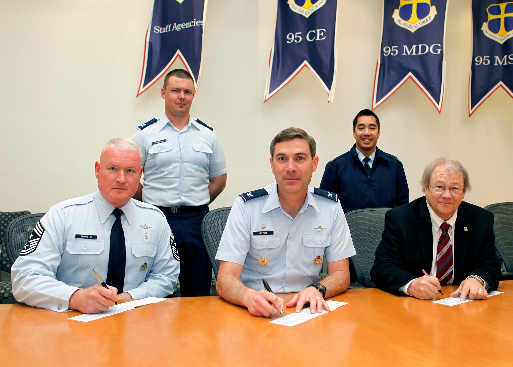 Signing-up for the Air Force Assistance Fund campaign March 12, Chief Master Sgt. Bill Thomaston (left), 95th Air Base Wing command chief, Col. Gregory Schwab, 95th ABW commander, and Mr. Robert Wood, chief of Environmental Management, all consider their options for charitable giving with the help of AFAF campaign installation project officers Capt. Scott Burrows (back left) and Capt. Ronald Elazegui. (U.S. Air Force photo by Jet Fabara) 